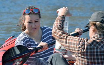 Students in a boat doing water sampling in Greenland