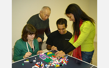 Photo of a a team working on one of the tasks used in the study involving Legos.