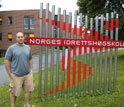 GROW student Erich Petushek standing next to a sign at the Norwegian School of Sports Sciences