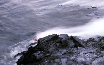 Blocks of lava fall in the sea at sea entry point of Kilauea