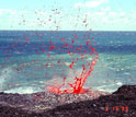 Photo showing lava splattering near the coastal entry of Kilauea.