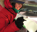 Photo of a researcher inspecting a freshly-drilled ice core.