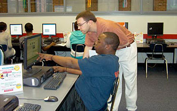 Photo of Dan DuBrow assisting a student who is remotely accessing radiation equipment.