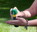 woman spraying insect repellant on hands