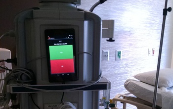 Android Nexus 7 tablets attached to  a monitor next to intensive care hospital bed