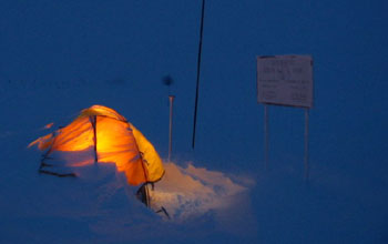 A researcher's tent at the geographic South Pole casts an eerie glow