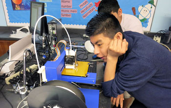 Buford Middle School student watches a 3-D printer at work