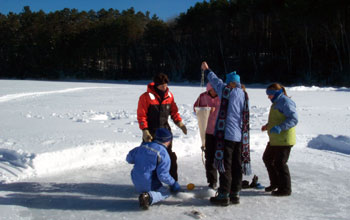 Seventh-graders collect zoo plankton through a hole in the ice
