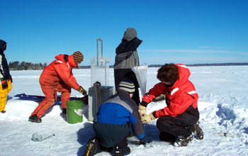 Third-graders collect zoo plankton through a hole in the ice