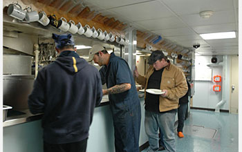 Photo of three people getting their lunch.