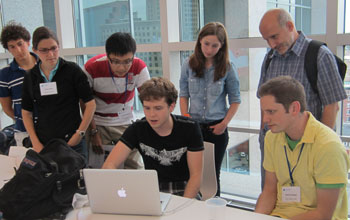Undergraduate students with faculty leader, Sergei Tabachnikov, working on a computer