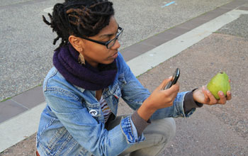 Photo of a young woman taking a photo for a paper prototype used to demonstrate the Forage City app.
