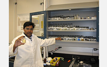 Photo of Sudipta Seal holding a bottle containing billions of ultra-small, engineered nanoceria.