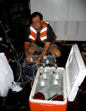 Photo of David Hutchins preparing an experiment with marine microbes.