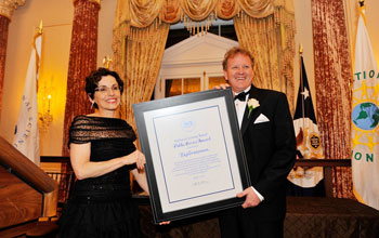 Photo of NSB's France Córdova presenting NSB's Public Service Award for a group to Dennis Bartels.