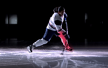 A hockey player on the ice making a slapshot