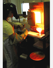 Photo of Amy Barnes making phosphorus-rich phosphate glass to use with her doctoral research work.