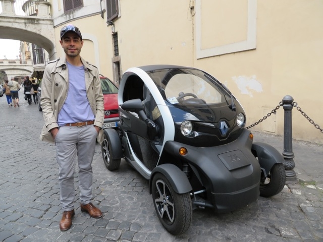 Ricardo Daziano stands next to a full-electric vehicle in Rome, Italy.