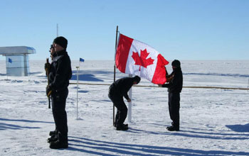 A memorial ceremony in Antarctica showing people and the Canadian flag.
