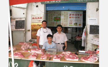 Photo of David Ortega and Laping Wu with a pork seller in Shijiazhuang, Hebei Province, China.