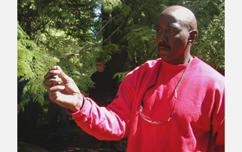 Photo of a Cedar Creek inmate and researcher in the Moss-in-Prisons project holding moss.