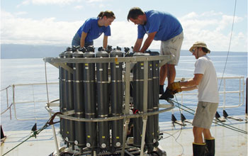 Photo of scientists preparing a rosette that will bring back seawater samples.