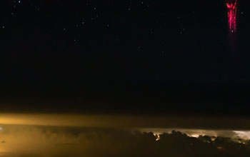 Above a thunderstorm's black clouds, red sprites mimic lightning.