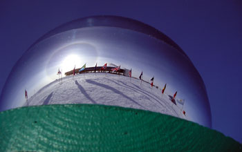 Flags reflected in ceremonial pole at Amundsen-Scott South Pole Station
