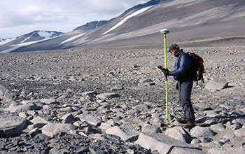 A surveyor collects survey points along the edge of the Boulder Pavement Scientific Zone