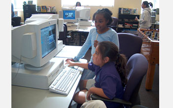 Photo of middle school children working at a computer.