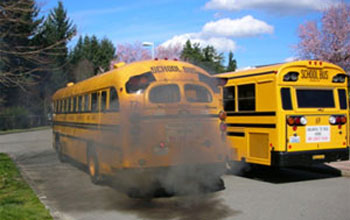 School bus spewing smoke through exhaust pipe