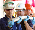 Photo of shipboard scientists carrying a core from volcanoes in the Louisville Seamount Trail.