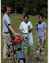 Photo of researchers sampling arthropods from sleepy grass with the Burkhard Vortis suction sampler.