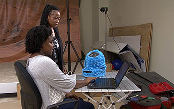 a teacher and a student programming a robot