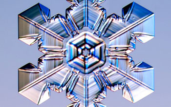 a stellar plate snow crystal with ridges pointing to corners between adjacent prism facets.