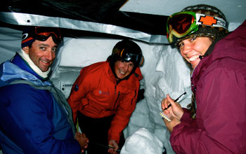 Photo of Noah Molotch, Danielle Perot and Ty Atkins studying snow properties from inside a snow pit.
