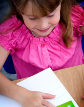 Photo of a young girl using a ruler on a piece of paper.