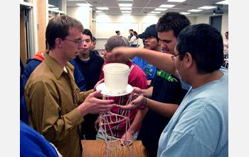 Students test the strength of a straw tower they built during a Sunday Academy