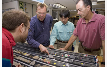 Photo of Chad Broyles, Jorg Geldmacher, Takashi Sano and Will Sager looking at a Shatsky Rise core.