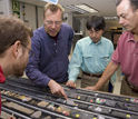 Photo of Chad Broyles, Jorg Geldmacher, Takashi Sano and Will Sager looking at a Shatsky Rise core.