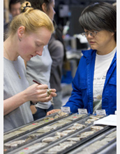 Photo of scientists Adelie Delacour and Chieh Peng working at the onboard sampling table.