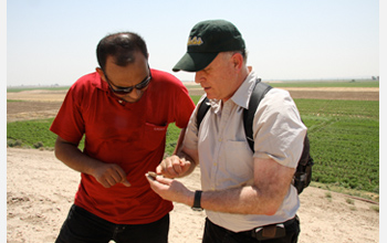 Photo of project co-directors Annas and Gil Stein examining a sherd of pottery at Tell Zeidan.