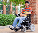 Photo of Xueliang Huo moving his tongue to direct the Tongue Drive System to move the wheelchair.