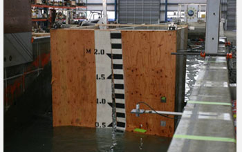 Photo showing a wooden shear wall upon failure caused by a 0.7m high tsunami wave breaking on wall.