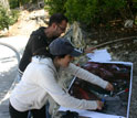 Research assistants review satellite imagery during a field visit