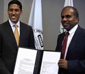 USAID Administrator Rajiv Shah on left and NSF Director Subra Suresh on right holding memorandum.