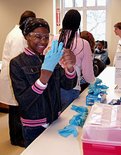 Photo of girl putting on gloves in the lab.