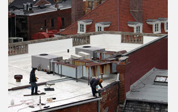 Photo of a construction crew painting a white roof in downtown Washington, D.C.