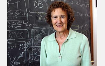 Photo of Barbara Liskov of MIT in front of a chalk board.