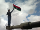 a rebel waves a Libyan flag